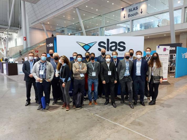 DIGI-B-CUBE team in front of a roll up at SLAS 2022